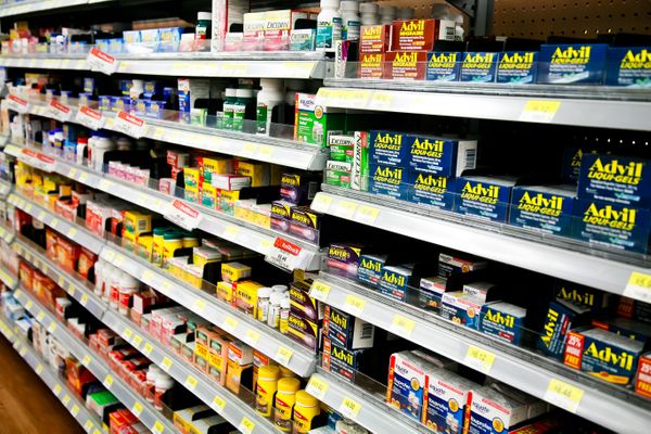 Pharmacist assisting customer at modern pharmacy counter